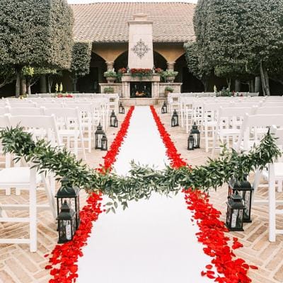 Outdoor wedding setup with chairs and decorations.