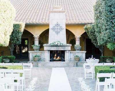 Outdoor courtyard with fireplace and seating arrangement.