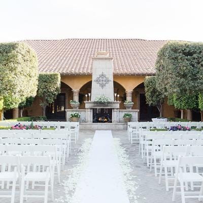 Outdoor wedding setup with chairs and decorations.