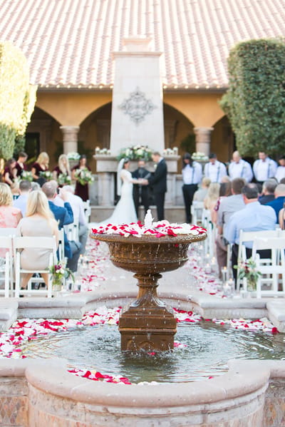 Outdoor wedding ceremony with guests and floral decor.