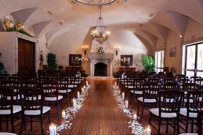 Interior view of a ceremony setup with chairs and candles.