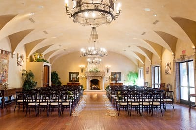 Interior event space with rows of chairs and chandeliers.