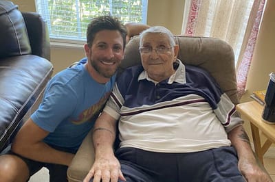 Smiling resident and staff member in a cozy setting.