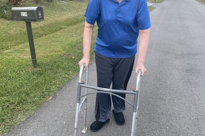 Senior using a walker on a residential street.