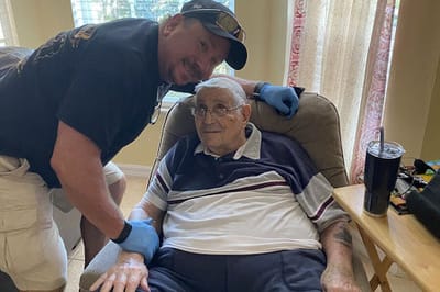 Staff member assisting a senior resident indoors.