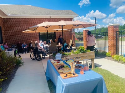 Residents enjoying an outdoor gathering with food.