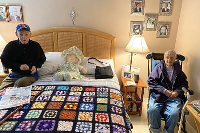 Two residents seated in a cozy interior room.