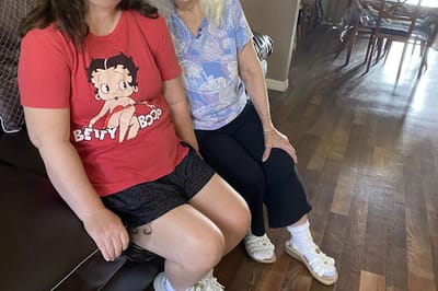 Two women sitting together in a common area.