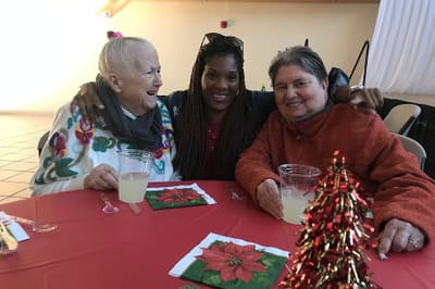 Three women enjoying a holiday celebration together.
