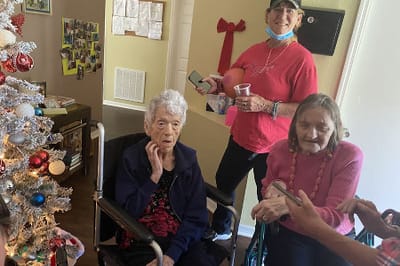 Residents participating in an activity near a decorated tree.