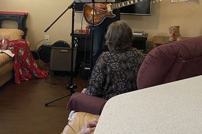 Residents enjoying a musical performance in the lounge.