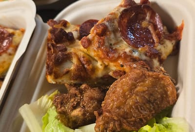 Close-up of pizza and fried chicken on lettuce