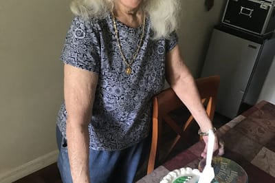 Senior woman enjoying cake at a celebration.
