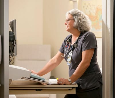 Healthcare worker assisting a patient in a care setting.