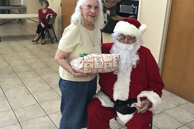 Resident with Santa during a holiday celebration.