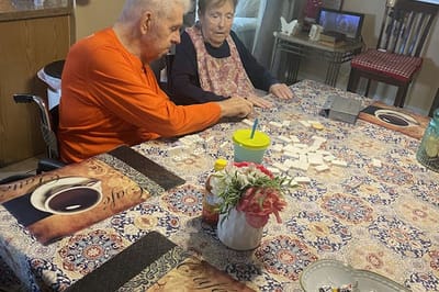 Two residents engaged in a game at a table.