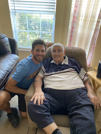 A senior man sitting with a caregiver