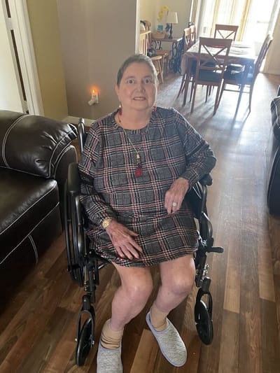 Resident in a wheelchair in a living room.