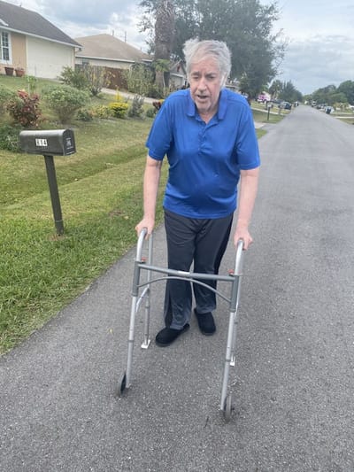 Senior man using a walker on a residential street.