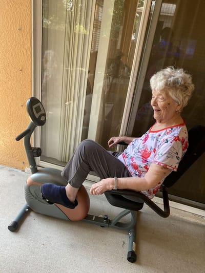 Senior resident exercising on a fitness bike.