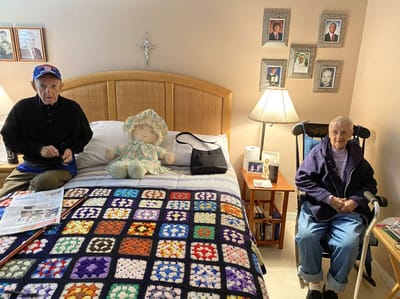 Two residents sitting in a cozy bedroom