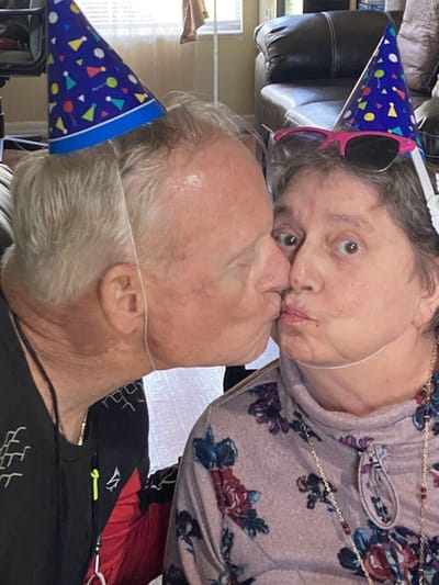 Two residents celebrating with party hats and playful expressions.