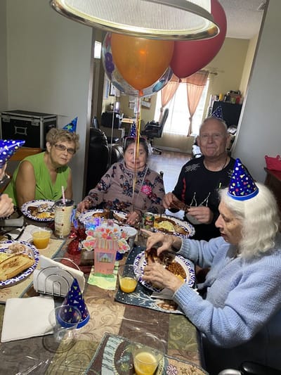 Residents celebrating a birthday with food and decorations.