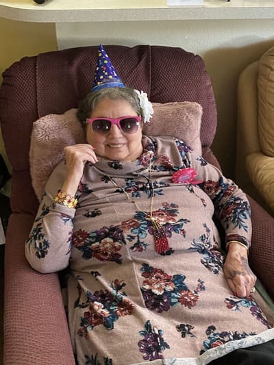 Senior resident celebrating with a party hat and sunglasses