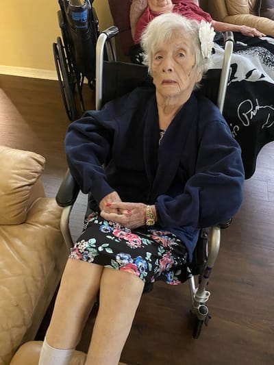 Senior resident sitting in a wheelchair indoors.