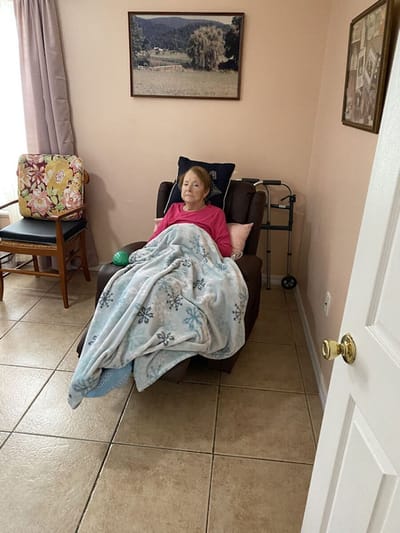 Senior resident relaxing in a chair with a blanket