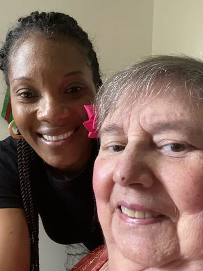 A smiling caregiver and resident taking a selfie.