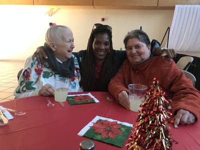 Three women enjoying a festive gathering together.