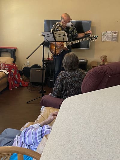 Musician performing for residents in a common area.