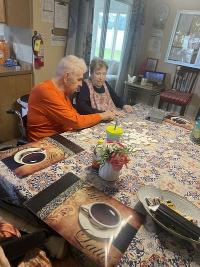 Residents engaging in a game at a communal table.