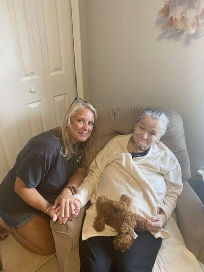 A caregiver with an elderly resident seated together.
