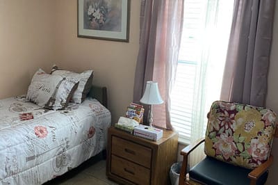 Cozy resident room with bed and chair.