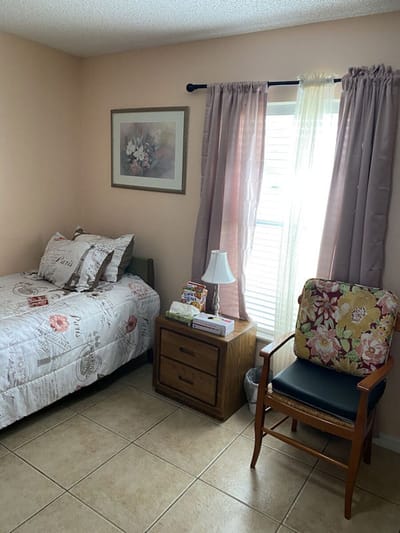 Cozy resident room with bed and chair.