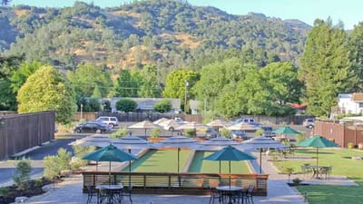 Outdoor seating area with gardens and mountains in the background.