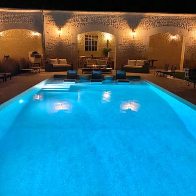 Illuminated pool area with lounge chairs