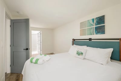 Cozy bedroom with a tidy bed and decorative wall art.