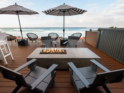 Outdoor seating area with fire pit and umbrellas