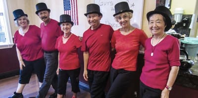 Residents engaged in a dance activity wearing hats.