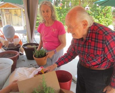 Residents engaging in gardening activity outdoors.
