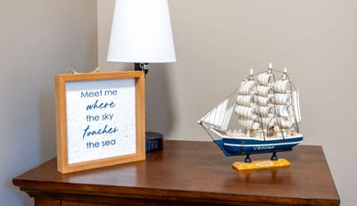 Decorative frame and ship model on a table.