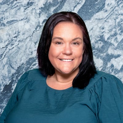 Smiling staff member in a teal top