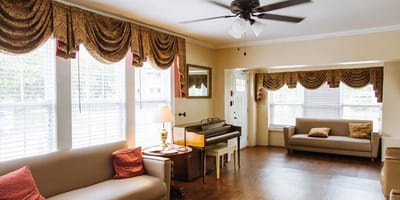 Cozy common area with seating and piano.