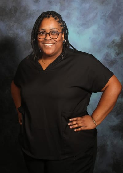 Smiling staff member in black uniform.