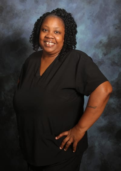 Smiling staff member in black scrubs