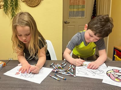 Two children coloring at a table.