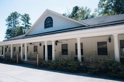 Exterior view of Kingston Wellness Retreat with rocking chairs.
